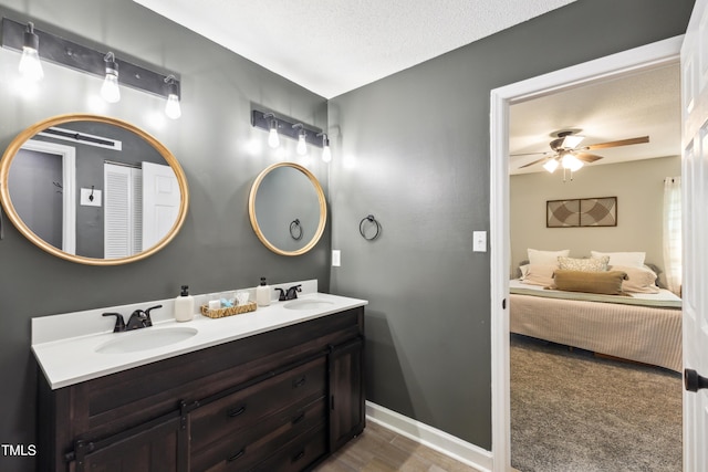 ensuite bathroom with double vanity, ceiling fan, a sink, and ensuite bathroom