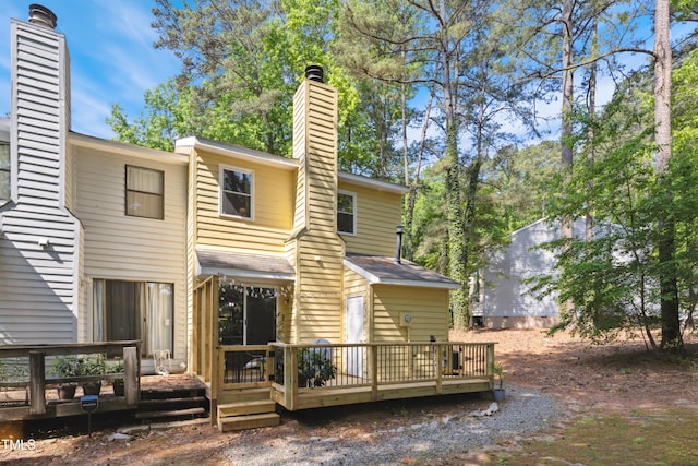 rear view of property featuring a wooden deck and a chimney