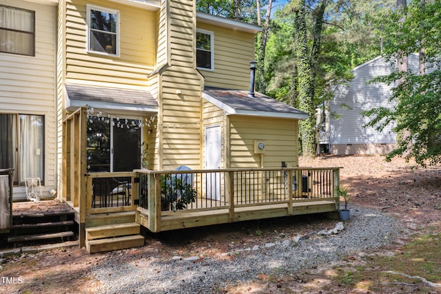 back of house featuring a wooden deck and a chimney