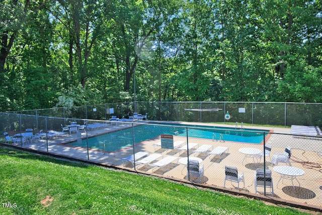 community pool with fence, a yard, and a patio area