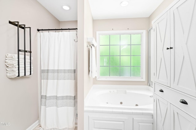 full bathroom featuring a whirlpool tub, a wealth of natural light, and a shower with curtain