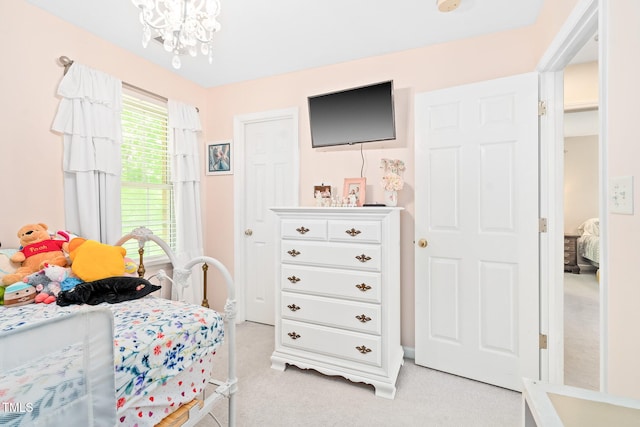 bedroom with light carpet and a chandelier