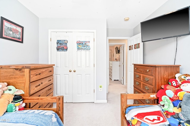 bedroom with baseboards, light colored carpet, and a closet