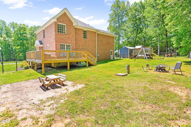 rear view of house featuring brick siding, a playground, an outdoor fire pit, and a fenced backyard