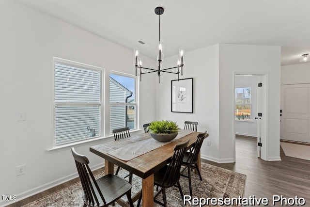 dining room featuring baseboards, wood finished floors, and a chandelier