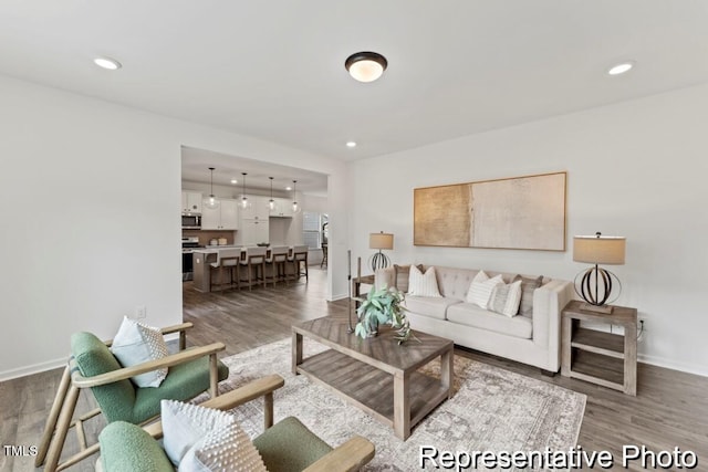 living room with baseboards, recessed lighting, and wood finished floors