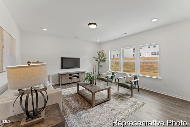living area featuring recessed lighting, baseboards, and wood finished floors