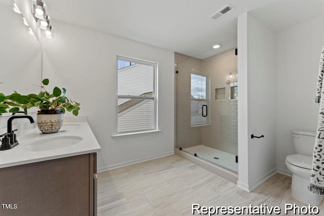 full bathroom featuring baseboards, a sink, a stall shower, and toilet