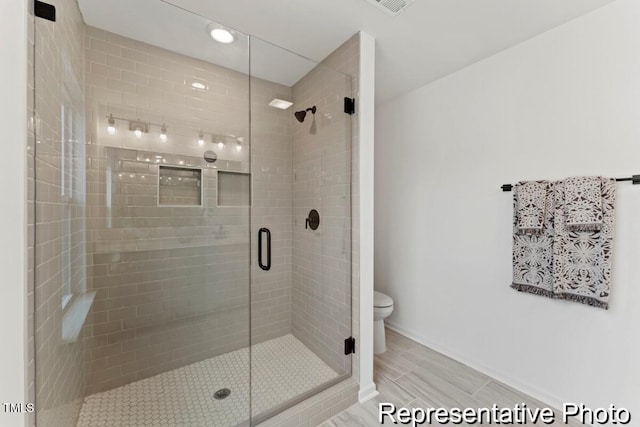 bathroom featuring recessed lighting, toilet, and a shower stall