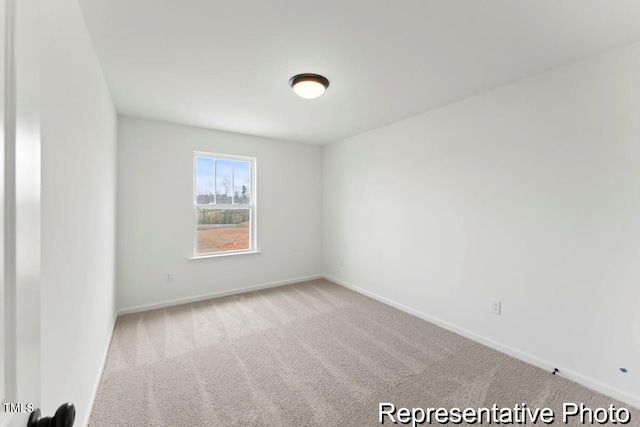 spare room featuring baseboards and carpet flooring