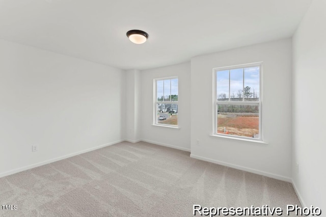 spare room with baseboards and carpet