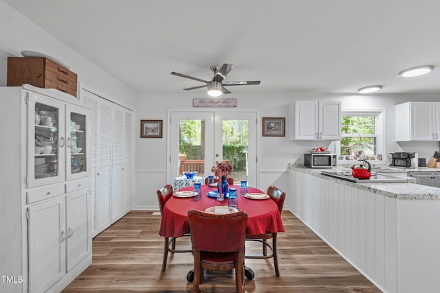 dining space featuring wood finished floors, plenty of natural light, and ceiling fan