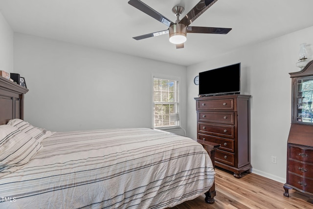 bedroom featuring light wood-style flooring, baseboards, and a ceiling fan
