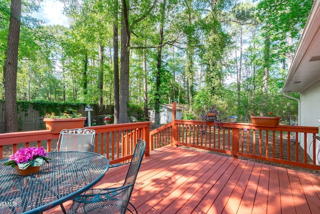 wooden deck featuring outdoor dining area and a fenced backyard