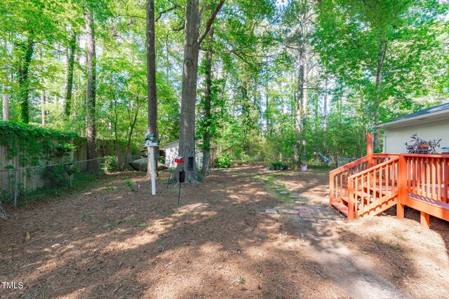 view of yard featuring fence and a deck