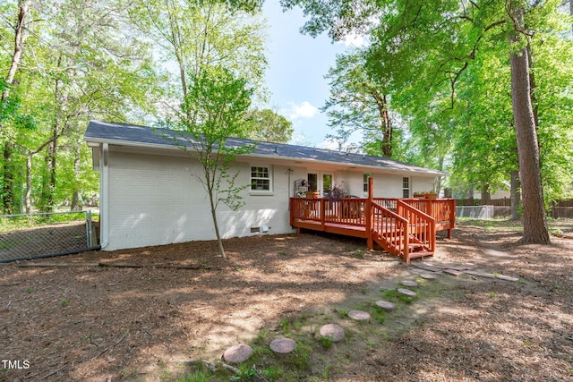 back of property featuring a deck, fence, crawl space, and brick siding