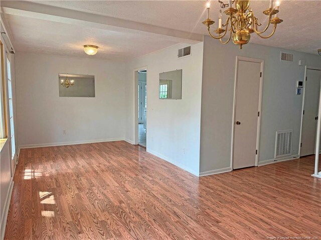 161 Lakeview Dr, Southern Pines, NC 28387 - empty room with a chandelier, wood finished floors, and visible vents