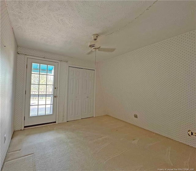 161 Lakeview Dr, Southern Pines, NC 28387 - unfurnished bedroom featuring ceiling fan, light carpet, wallpapered walls, and a textured ceiling
