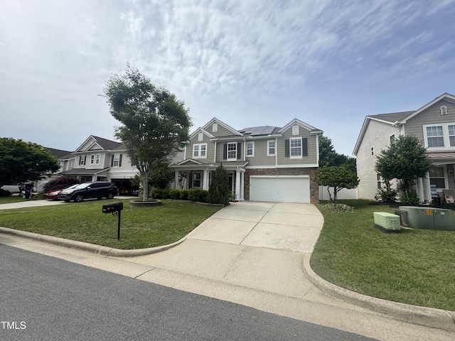 view of front of house featuring solar panels, driveway, a front yard, and a garage