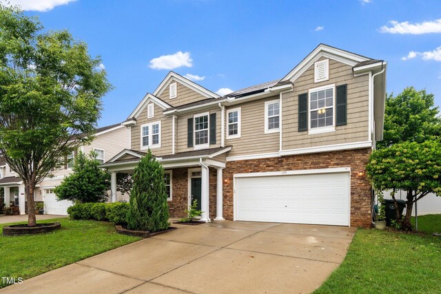 149 Cinder Cross Way, Garner, NC 27529 - view of front of home with driveway, an attached garage, roof mounted solar panels, and a front lawn