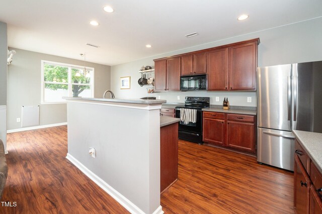 149 Cinder Cross Way, Garner, NC 27529 - kitchen with black appliances, dark wood finished floors, recessed lighting, light countertops, and a kitchen island with sink