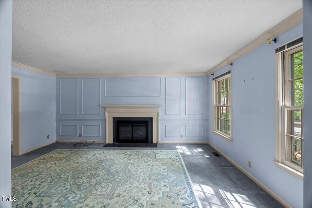 3025 Wycliff Rd, Raleigh, NC 27607 - unfurnished living room featuring a textured ceiling, healthy amount of natural light, carpet, baseboards, and a fireplace with flush hearth