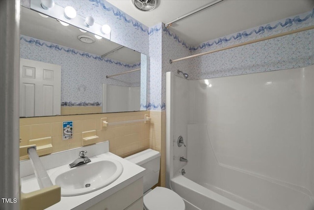 3025 Wycliff Rd, Raleigh, NC 27607 - bathroom with shower / tub combination, tile walls, vanity, toilet, and wallpapered walls