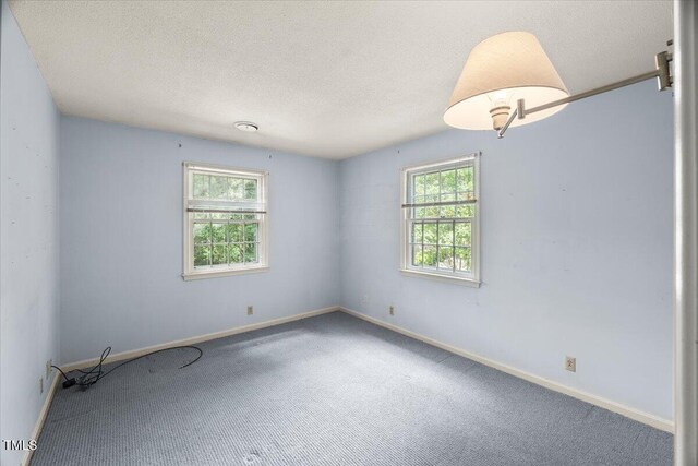 3025 Wycliff Rd, Raleigh, NC 27607 - carpeted empty room featuring baseboards and a textured ceiling