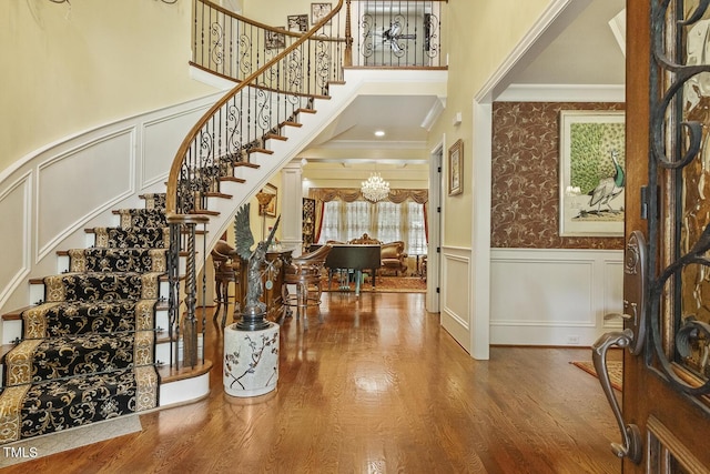 5901 Charleycote Dr, Raleigh, NC 27614 - foyer with crown molding, wood finished floors, stairway, a wainscoted wall, and a notable chandelier