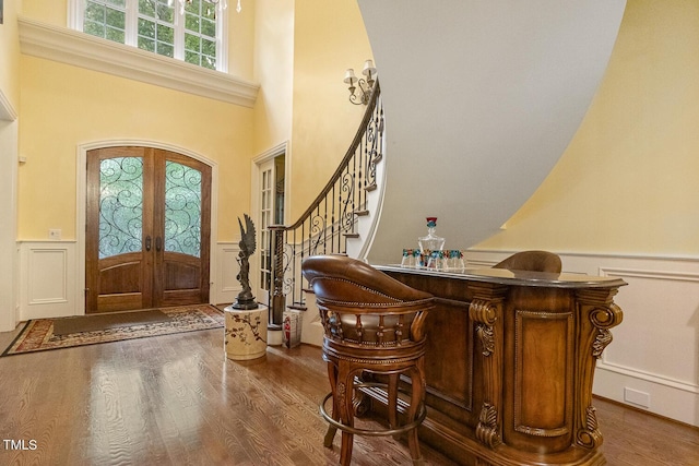 5901 Charleycote Dr, Raleigh, NC 27614 - foyer entrance featuring wainscoting, a decorative wall, french doors, and wood finished floors