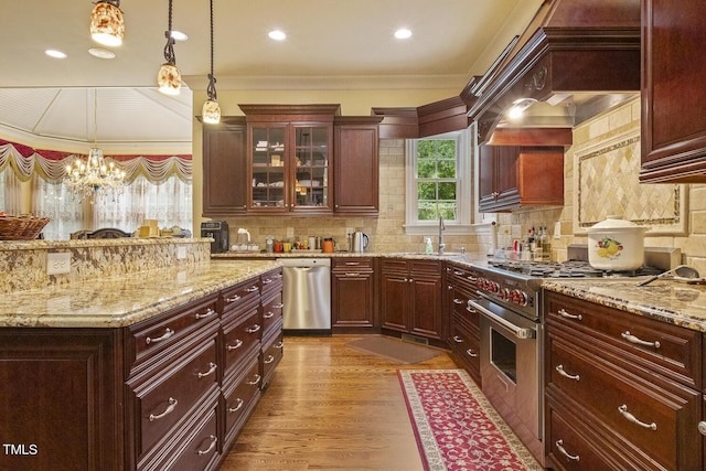 5901 Charleycote Dr, Raleigh, NC 27614 - kitchen featuring pendant lighting, appliances with stainless steel finishes, a sink, glass insert cabinets, and ornamental molding