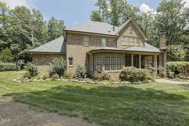 5901 Charleycote Dr, Raleigh, NC 27614 - rear view of house featuring brick siding, a yard, a chimney, and a porch