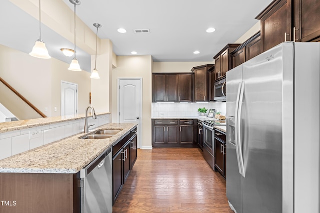 1104 Arden Trace Ct, Fuquay Varina, NC 27526 - kitchen with appliances with stainless steel finishes, a sink, dark brown cabinets, light wood-style flooring, and light stone counters