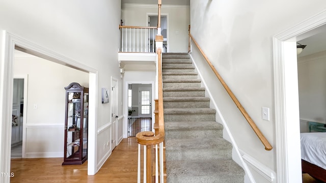 staircase with a high ceiling and wood finished floors