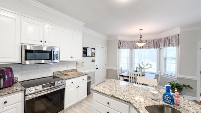 kitchen with white cabinets, appliances with stainless steel finishes, light stone counters, and tasteful backsplash
