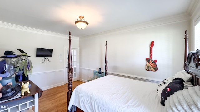 bedroom with crown molding and wood finished floors