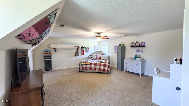 bedroom with a ceiling fan, a textured ceiling, visible vents, and light carpet
