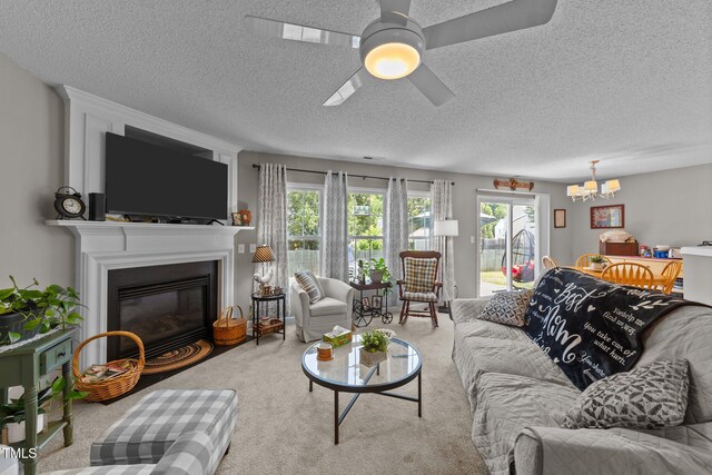 228 Honeywell Way, Fuquay Varina, NC 27526 - carpeted living area with a textured ceiling, a glass covered fireplace, and ceiling fan with notable chandelier