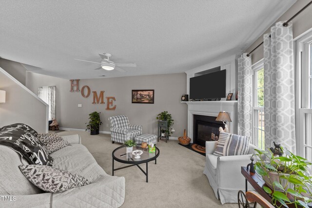 228 Honeywell Way, Fuquay Varina, NC 27526 - living area featuring a glass covered fireplace, a ceiling fan, a textured ceiling, and light colored carpet
