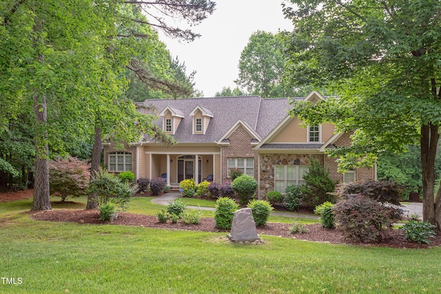 cape cod house featuring a front yard