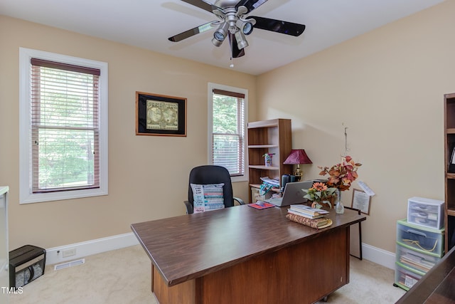 home office featuring a ceiling fan, light colored carpet, and baseboards