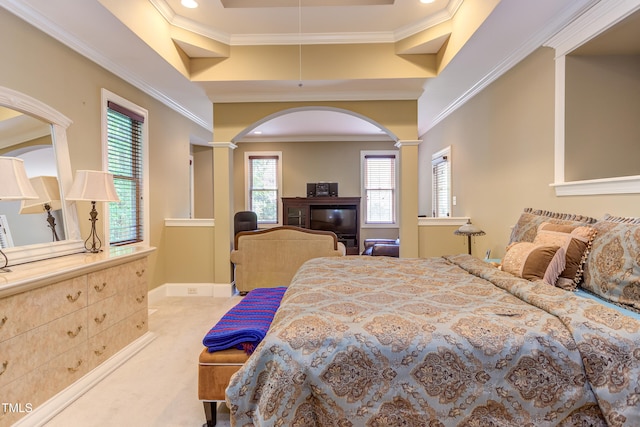 bedroom featuring arched walkways, crown molding, a raised ceiling, and light carpet