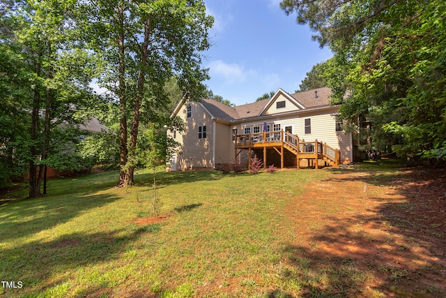 rear view of house featuring stairs, a wooden deck, and a lawn