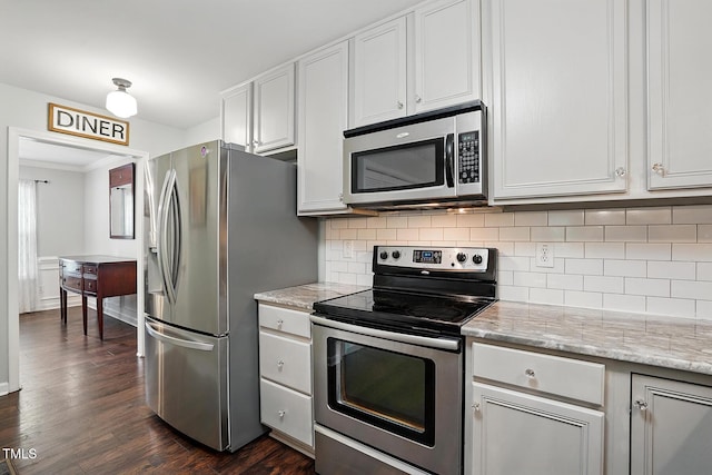 kitchen with appliances with stainless steel finishes, backsplash, dark wood-type flooring, and ornamental molding