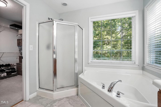 full bath featuring a stall shower, a garden tub, and a spacious closet