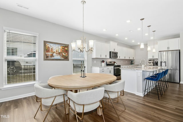 5009 Megara Run, Raleigh, NC 27603 - dining room featuring a chandelier, dark wood-style flooring, recessed lighting, and baseboards