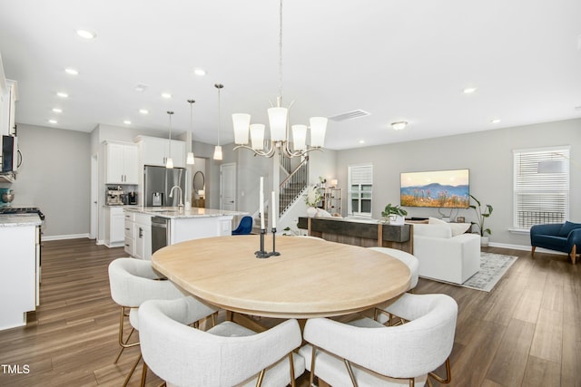 5009 Megara Run, Raleigh, NC 27603 - dining area featuring recessed lighting, baseboards, dark wood-style flooring, a chandelier, and stairs