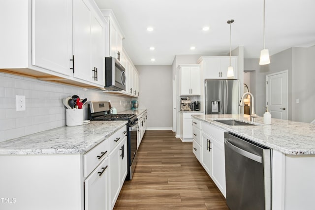 5009 Megara Run, Raleigh, NC 27603 - kitchen featuring stainless steel appliances, a sink, wood finished floors, backsplash, and white cabinetry