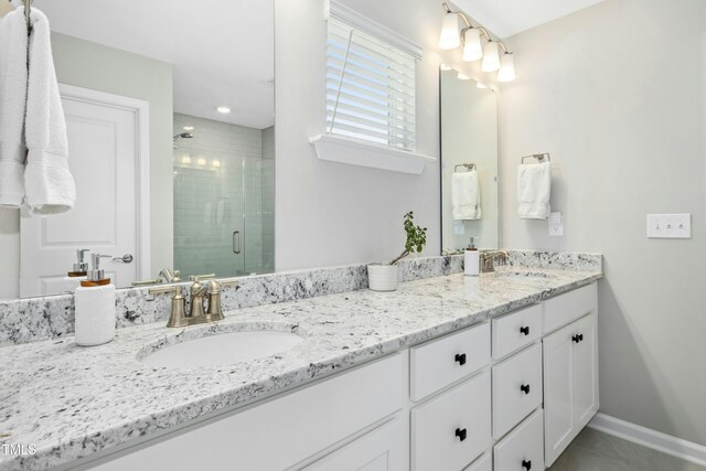 5009 Megara Run, Raleigh, NC 27603 - bathroom with double vanity, a stall shower, baseboards, and tile patterned flooring
