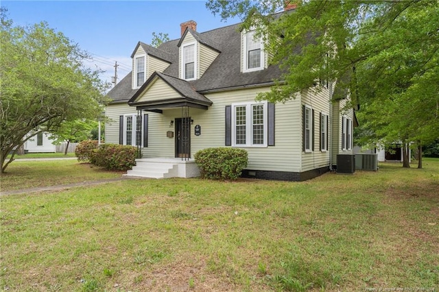 cape cod house featuring central AC unit, a chimney, and a front lawn